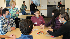 Sheryl stands next to a table of DO-IT participants, participating in a discussion.