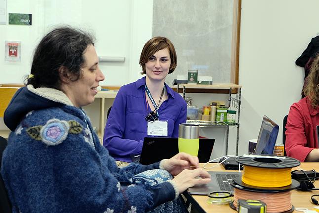 Disabled instructor Jen Mankoff shares a table with students, all working on computers.